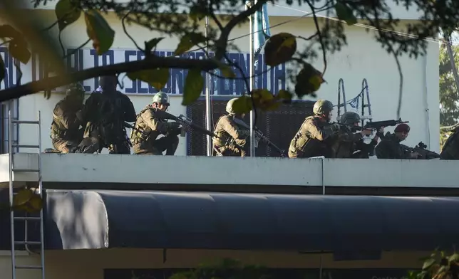 Security forces enter the Renovation maximum-security prison to free guards taken hostage and retake control of the facility, which houses gang leaders, in Escuintla, Guatemala, Sunday, Jan. 18, 2026. (AP Photo/Moises Castillo)