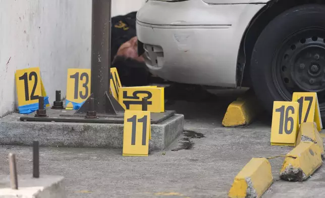 Evidence markers stand at the scene where police officers were killed in attacks reported after security forces retook control of a prison that houses gang leaders, in Villanueva, on the outskirts of Guatemala City, Sunday, Jan. 18, 2026. (AP Photo/Moises Castillo)