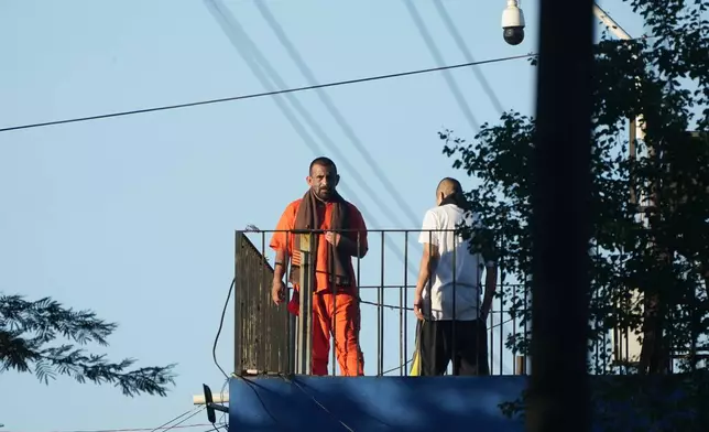 Inmates stand atop a guard tower at the Renovation maximum-security prison before security forces entered the facility to free guards taken hostage in Escuintla, Guatemala, Sunday, Jan. 18, 2026. (AP Photo/Moises Castillo)