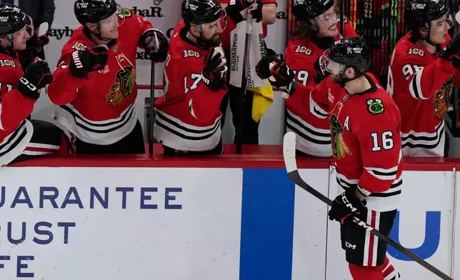 Chicago Blackhawks center Jason Dickinson (16) celebrates with teammates after scoring during the second period of an NHL hockey game against the Winnipeg Jets in Chicago, Monday, Jan. 19, 2026. (AP Photo/Nam Y. Huh)