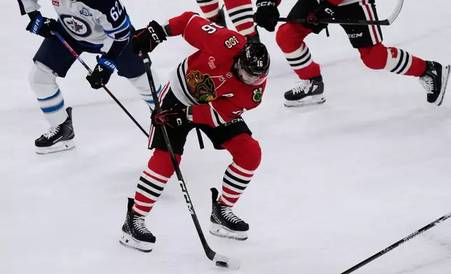 Chicago Blackhawks center Jason Dickinson (16) controls the puck during the first period of an NHL hockey game against the Winnipeg Jets in Chicago, Monday, Jan. 19, 2026. (AP Photo/Nam Y. Huh)