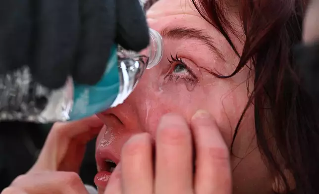 A protester receives aid after confronting law enforcement outside the Bishop Henry Whipple Federal Building, Thursday, Jan. 8, 2026, in Minneapolis, Minn. (AP Photo/Tom Baker)