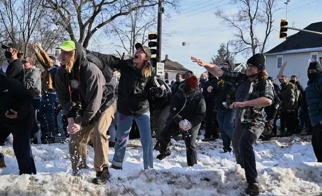 People protest as law enforcement officers attend to the scene of the shooting involving federal law enforcement agents, Wednesday, Jan. 7, 2026, in Minneapolis. (AP Photo/Tom Baker)