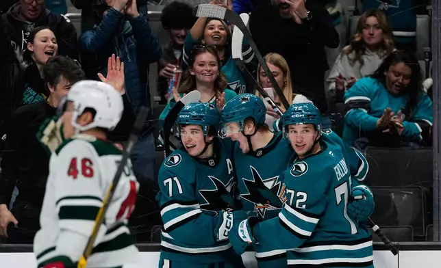 San Jose Sharks center Macklin Celebrini (71) celebrates with left wings Igor Chernyshov (92) and William Eklund (72) after scoring a goal during the third period of an NHL hockey game against the Minnesota Wild, Wednesday, Dec. 31, 2025, in San Jose, Calif. (AP Photo/Godofredo A. Vásquez)