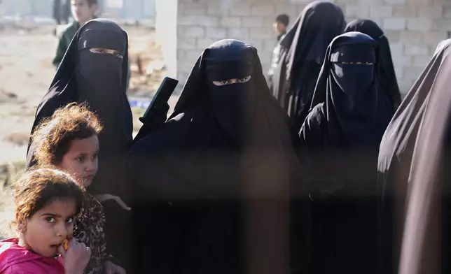 People stand inside the al-Hol camp in northeastern Syria's Hasakeh province, Syria, Wednesday, Jan. 21, 2026, after the withdrawal of the Syrian Democratic Forces (SDF). (AP Photo/Ghaith Alsayed)