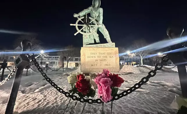 Flowers are seen placed at the Gloucester Fisherman's Memorial in Gloucester, Mass., after a fishing boat from port city went missing off the coast of Massachusetts with multiple people on board, Friday, Jan. 30, 2026. (AP Photo/Robert F. Bukaty)