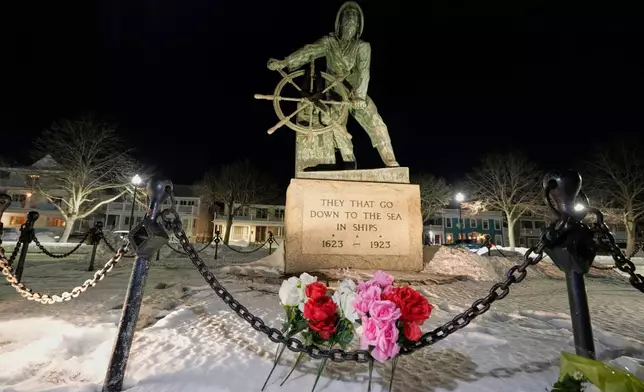 Flowers are seen placed at the Gloucester Fisherman's Memorial in Gloucester, Mass., after a fishing boat from port city went missing off the coast of Massachusetts with multiple people on board, Friday, Jan. 30, 2026. (AP Photo/Robert F. Bukaty)