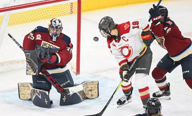 Ottawa Charge's Brianne Jenner (19) moves in on Montreal Victoire goaltender Ann-Renee Desbiens (35) as Victoire's Hayley Scamurra (16) defends during the second period of an PWHL hockey game in Laval, Que., Saturday, Jan. 24, 2026. (Graham Hughes/The Canadian Press via AP)