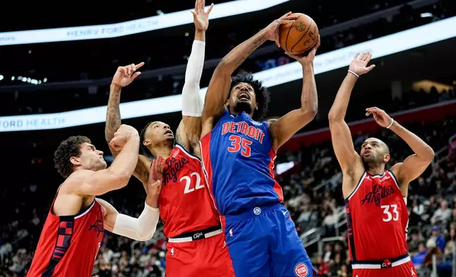 Detroit Pistons forward Tolu Smith, third from left, shoots against Los Angeles Clippers center Brook Lopez, guard Jordan Miller, and forward Nic Batum, from left, during the first half of an NBA basketball game Saturday, Jan. 10, 2026, in Detroit. (AP Photo/Ryan Sun)
