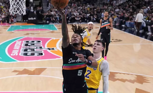 San Antonio Spurs guard Stephon Castle (5) scores past Los Angeles Lakers forward Jake Laravia (12) during the first half of an NBA basketball game in San Antonio, Wednesday, Jan. 7, 2026. (AP Photo/Eric Gay)