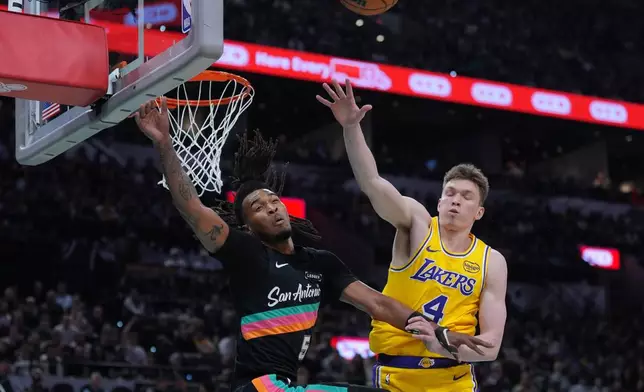 San Antonio Spurs guard Stephon Castle (5) and Los Angeles Lakers forward Dalton Knecht (4) reach for a rebound during the first half of an NBA basketball game in San Antonio, Wednesday, Jan. 7, 2026. (AP Photo/Eric Gay)