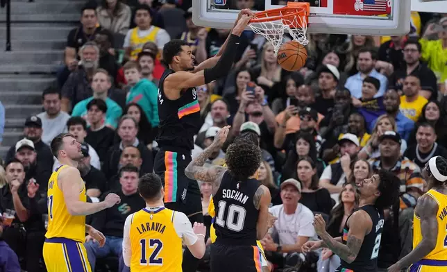 San Antonio Spurs forward Victor Wembanyama (1) scores against the Los Angeles Lakers during the second half of an NBA basketball game in San Antonio, Wednesday, Jan. 7, 2026. (AP Photo/Eric Gay)