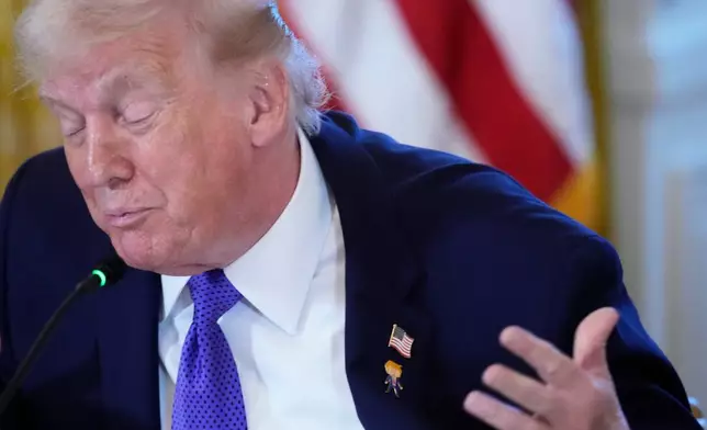 President Donald Trump wears a gift, which he calls a "Happy Trump" pin, during a meeting with oil executives in the East Room of the White House, Friday, Jan. 9, 2026, in Washington. (AP Photo/Alex Brandon)