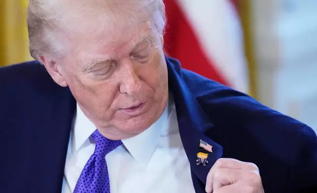 President Donald Trump wears a gift, which he calls a "Happy Trump" pin, during a meeting with oil executives in the East Room of the White House, Friday, Jan. 9, 2026, in Washington. (AP Photo/Alex Brandon)