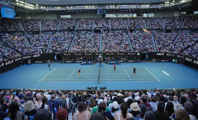 Andre Agassi of the United States and Roger Federer of Switzerland play doubles against Lleyton Hewitt and Pat Rafter of Australia during the Opening Ceremony for the Australian Open tennis championship in Melbourne, Australia, Saturday, Jan. 17, 2026. (AP Photo/Dita Alangkara)