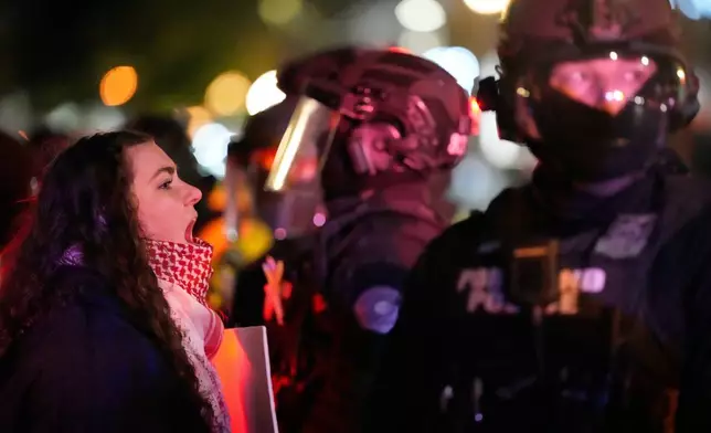 A protester yells at a Portland police officer outside the U.S. Immigration and Customs Enforcement facility on Thursday, Jan. 8, 2026, in Portland, Ore. (AP Photo/Jenny Kane)