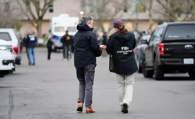 Law enforcement officials work the scene following reports that federal immigration officers shot and wounded people in Portland, Ore., Thursday, Jan. 8, 2026. (AP Photo/Jenny Kane)