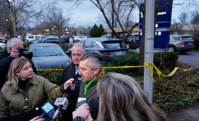 Multnomah County District Attorney Nathan Vasquez, center, speaks to the media following reports that federal immigration officers shot and wounded people in Portland, Ore., Thursday, Jan. 8, 2026. (AP Photo/Jenny Kane)