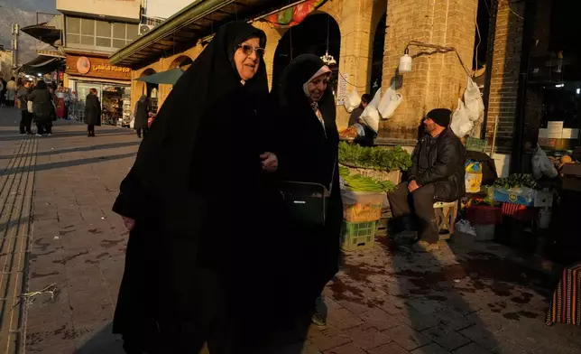 Women walk past the Tajrish bazaar in northern Tehran, Iran, Tuesday, Jan. 27, 2026. (AP Photo/Vahid Salemi)