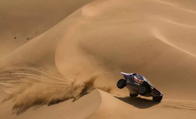 Driver Carlos Sainz and co-driver Lucas Cruz compete during the twelfth stage of the Dakar Rally between Al Henakiyah and Yanbu, Saudi Arabia, Friday, Jan.16, 2026. (AP Photo/Thibault Camus)