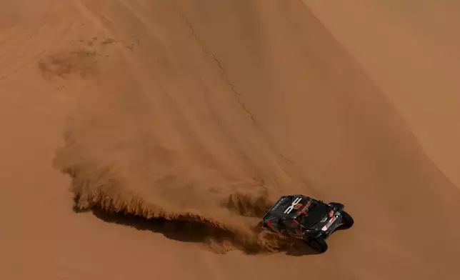 Driver Nasser Al-Attiyah and co-driver Fabian Lurquin compete during the twelfth stage of the Dakar Rally between Al Henakiyah and Yanbu, Saudi Arabia, Friday, Jan.16, 2026. (AP Photo/Thibault Camus)