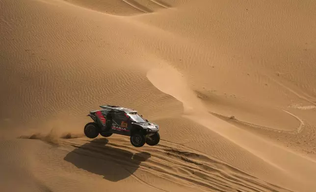 Driver Nasser Al-Attiyah and co-driver Fabian Lurquin compete during the twelfth stage of the Dakar Rally between Al Henakiyah and Yanbu, Saudi Arabia, Friday, Jan.16, 2026. (AP Photo/Thibault Camus)