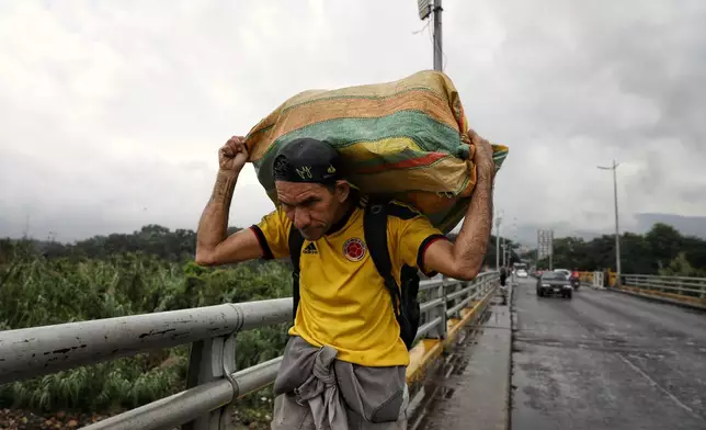 People cross the Colombian-Venezuelan border, in Villa del Rosario, Colombia, Monday, Jan. 5, 2026, two days after U.S. forces captured and removed Venezuelan President Nicolas Maduro. (AP Photo/Santiago Saldarriaga)