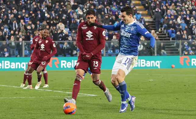 Como's Anastasios Douvikas, right, and Torino's Guillermo Maripan in action during the Serie A soccer match between Como and Torino in Como, Italy, Saturday Jan. 24, 2026. (Antonio Saia/LaPresse via AP)
