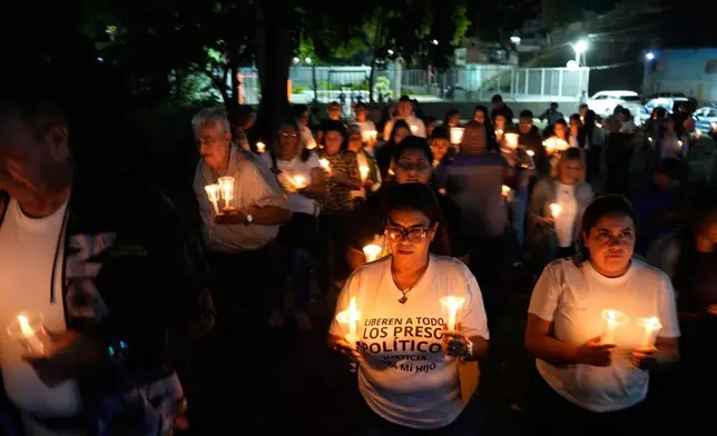 Relatives and friends of political prisoners hold candles calling for their loved ones to be set free outside the Rodeo I prison in Guatire, Venezuela, Friday, Jan. 9, 2026 after the government announced prisoners would be released. (AP Photo/Matias Delacroix)
