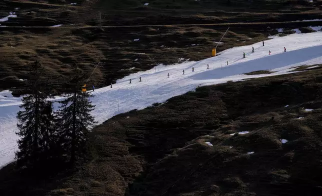 FILE - People ski on a hill with manufactured snow near Bayrischzell, Germany, Feb. 6, 2024. (AP Photo/Matthias Schrader, File)