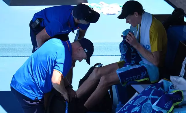 Jannik Sinner of Italy receives treatment from trainers during his third round match against Eliot Spizzirri of the U.S.at the Australian Open tennis championship in Melbourne, Australia, Saturday, Jan. 24, 2026. (AP Photo/Dita Alangkara)