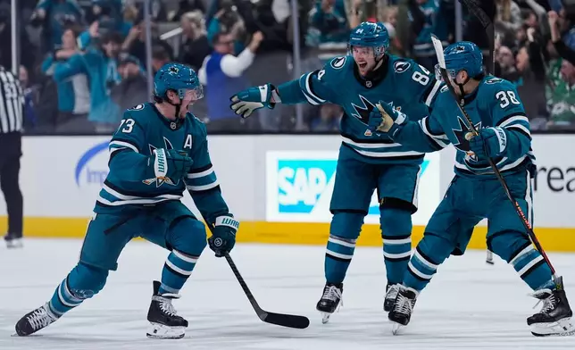 San Jose Sharks center Tyler Toffoli (73) celebrates with teammates after scoring the game-winning goal during overtime of an NHL hockey game against the Dallas Stars, Saturday, Jan. 10, 2026, in San Jose, Calif. (AP Photo/Godofredo A. Vásquez)