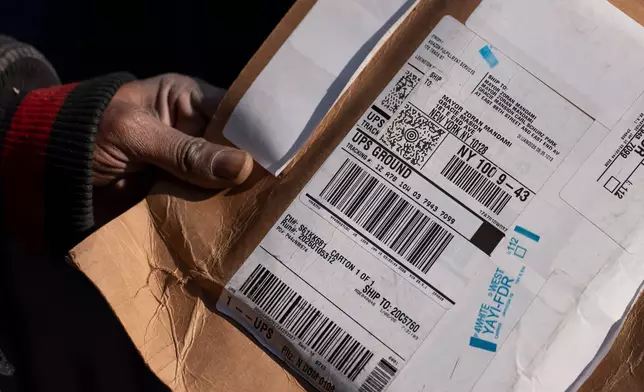A delivery worker shows a package sent to New York Mayor Zohran Mamdani outside Gracie Mansion, Monday, Jan. 12, 2026, in New York. (AP Photo/Yuki Iwamura)