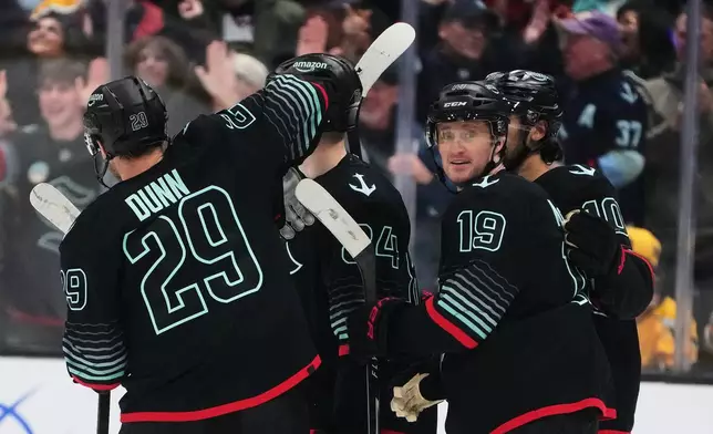 Seattle Kraken left wing Jared McCann (19) celebrates with defenseman Vince Dunn (29) after scoring against the Boston Bruins during the second period of an NHL hockey game Tuesday, Jan. 6, 2026, in Seattle. (AP Photo/Lindsey Wasson)