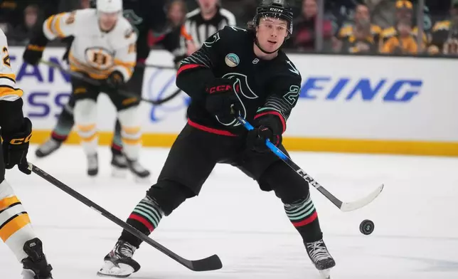 Seattle Kraken center Berkly Catton flicks the puck while facing the Boston Bruins during the third period of an NHL hockey game Tuesday, Jan. 6, 2026, in Seattle. (AP Photo/Lindsey Wasson)