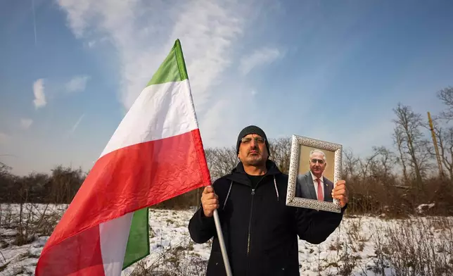 A member of the Iranian community holds a photograph of Iran's exiled crown prince Reza Pahlavi outside the U.S. embassy in Bucharest, Romania, Wednesday, Jan. 14, 2026, during a rally in support of anti-government protests in Iran. (AP Photo/Andreea Alexandru)