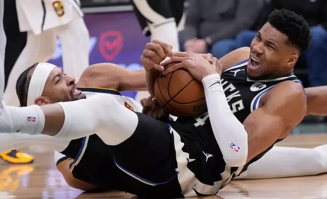 Milwaukee Bucks' Giannis Antetokounmpo, right, and Denver Nuggets' Zeke Nnaji battle for a loose ball during the second half of an NBA basketball game Friday, Jan. 23, 2026, in Milwaukee. (AP Photo/Morry Gash)