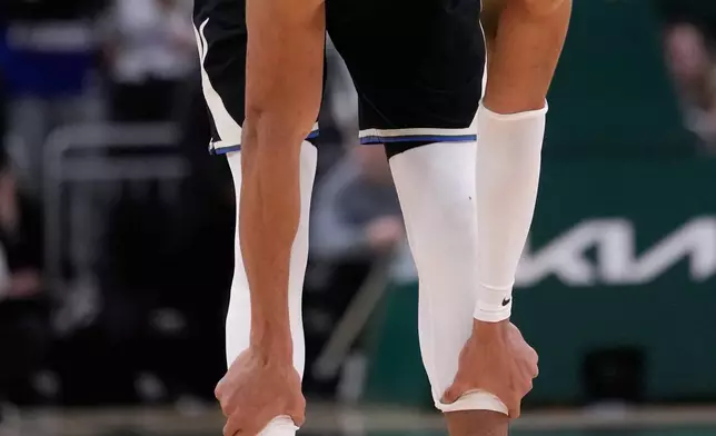 Milwaukee Bucks' Giannis Antetokounmpo holds his leg in the final seconds of the second half of an NBA basketball game against the Denver Nuggets Friday, Jan. 23, 2026, in Milwaukee. (AP Photo/Morry Gash)