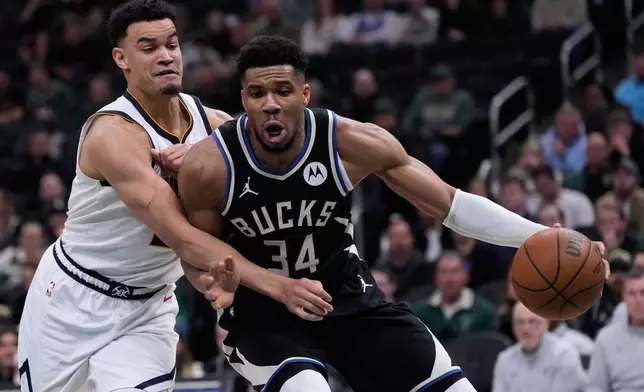 Milwaukee Bucks' Giannis Antetokounmpo (34) tries to get past Denver Nuggets' Spencer Jones during the second half of an NBA basketball game Friday, Jan. 23, 2026, in Milwaukee. (AP Photo/Morry Gash)