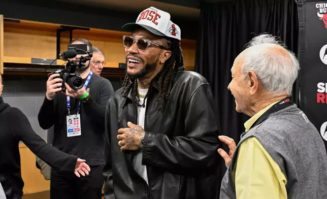 Former Chicago Bulls player Derrick Rose, center, laughs while talking with writer Sam Smith, right, after a press conference, before an NBA basketball game against the Boston Celtics, Saturday, Jan. 24, 2026, in Chicago. Rose's jersey will be retired after the game today. (AP Photo/Matt Marton)
