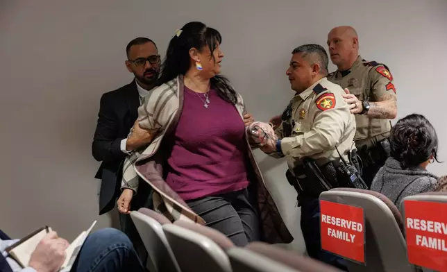 Police officers escort Velma Lisa Duran of the courtroom as she yells at witness Joe Vasquez, a Zavala County Sheriff's Office deputy, during a trial for former Uvalde school district police officer Adrian Gonzales at the Nueces County Courthouse in Corpus Christi, Texas, on Tuesday, Jan. 13, 2026. Duran's sister Irma Garcia was one of two teachers who were killed in the Robb Elementary mass shooting. (Sam Owens/The San Antonio Express-News via AP, Pool)