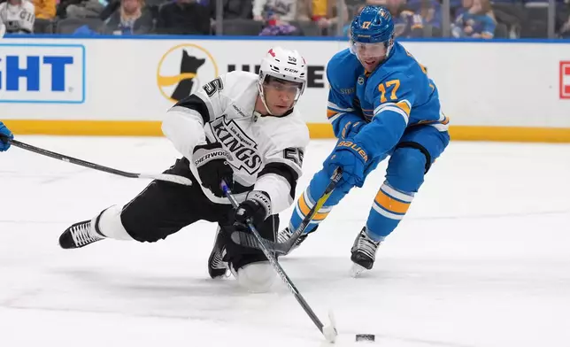 Los Angeles Kings' Quinton Byfield (55) and St. Louis Blues' Cam Fowler (17) battle for a loose puck during the third period of an NHL hockey game Saturday, Jan. 24, 2026, in St. Louis. (AP Photo/Jeff Roberson)