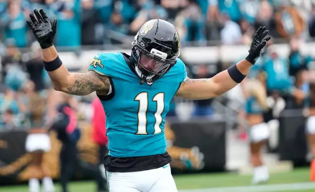 Jacksonville Jaguars wide receiver Parker Washington (11) celebrates his touchdown during the first half of an NFL football game against the Tennessee Titans, Sunday, Jan. 4, 2026, in Jacksonville, Fla. (AP Photo/John Raoux)