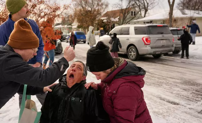 Bystanders are treated after being pepper sprayed as federal immigration officers make an arrest Sunday, Jan. 11, 2026, in Minneapolis. (AP Photo/John Locher)