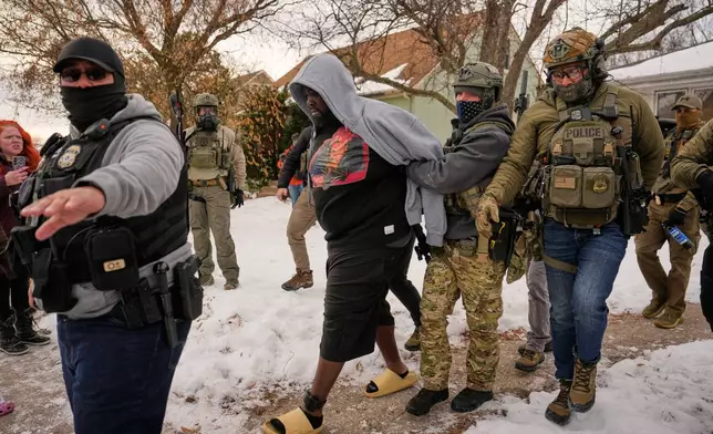 A man is arrested by federal immigration officers Sunday, Jan. 11, 2026, in Minneapolis. (AP Photo/John Locher)