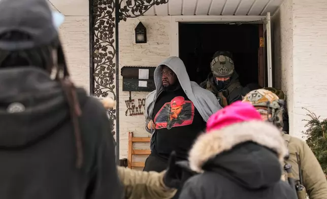 A man is arrested by federal immigration officers Sunday, Jan. 11, 2026, in Minneapolis. (AP Photo/John Locher)