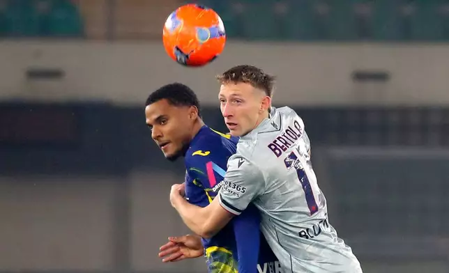 Udinese's Nicolo Bertola, right, and Verona's Amin Sarr in action during the Serie A soccer match between Hellas Verona and Udinese in Verona, Italy, Monday Jan. 26, 2026. (Paola Garbuio/LaPresse via AP)