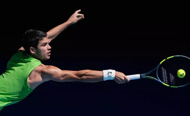 Carlos Alcaraz of Spain plays a backhand return to Corentin Moutet of France during their third round match at the Australian Open tennis championship in Melbourne, Australia, Friday, Jan. 23, 2026. (AP Photo/Asanka Brendon Ratnayake)