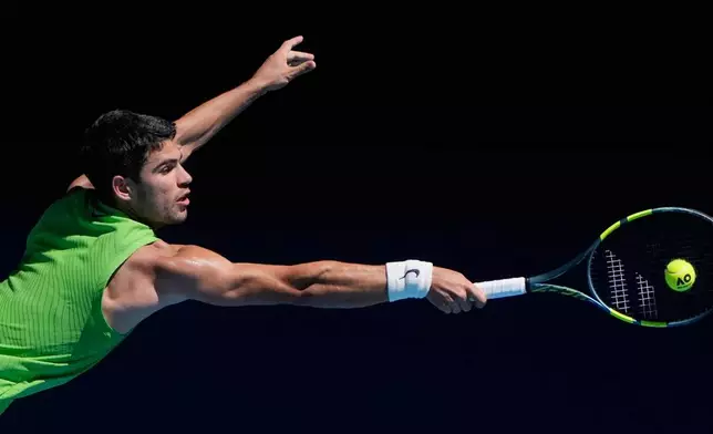 Carlos Alcaraz of Spain plays a backhand return to Corentin Moutet of France during their third round match at the Australian Open tennis championship in Melbourne, Australia, Friday, Jan. 23, 2026. (AP Photo/Asanka Brendon Ratnayake)