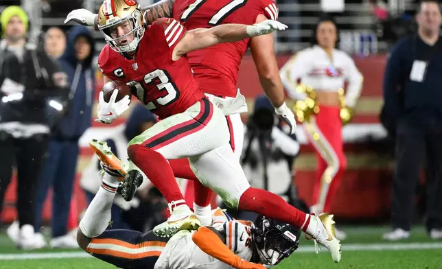 San Francisco 49ers running back Christian McCaffrey (23) runs against Chicago Bears safety C.J. Gardner-Johnson, bottom, during the second half of an NFL football game in Santa Clara, Calif., Sunday, Dec. 28, 2025. (AP Photo/Eakin Howard)